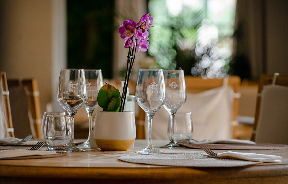 Table with wine glasses and a purple flower