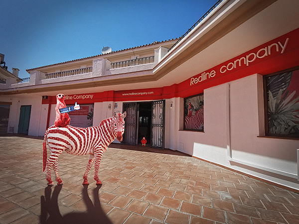 Red zebra and meerkat standing in front of Redline office created by Redline Company.
